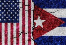 Cracked flags of the United States and Cuba on a textured surface