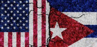 Cracked flags of the United States and Cuba on a textured surface