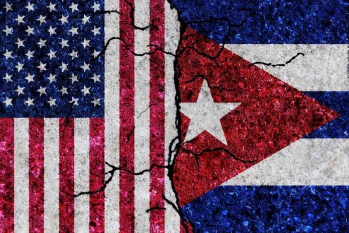 Cracked flags of the United States and Cuba on a textured surface