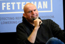 Fetterman Breaks Ranks With Dems — AGAIN! Bald man with goatee holding microphone.