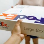 Person handing over a FedEx package to another individual