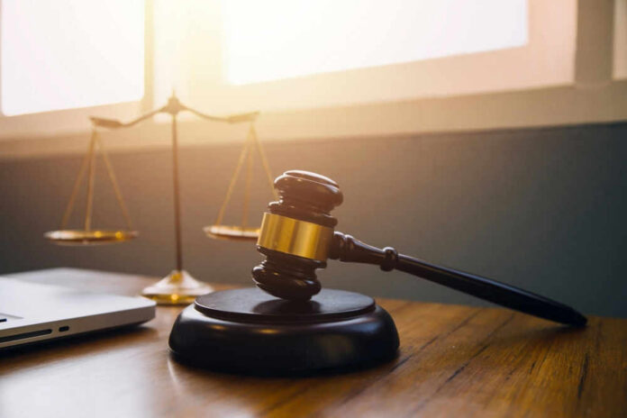 shutterstock_2347797923.jpg Gavel and scales of justice on desk.