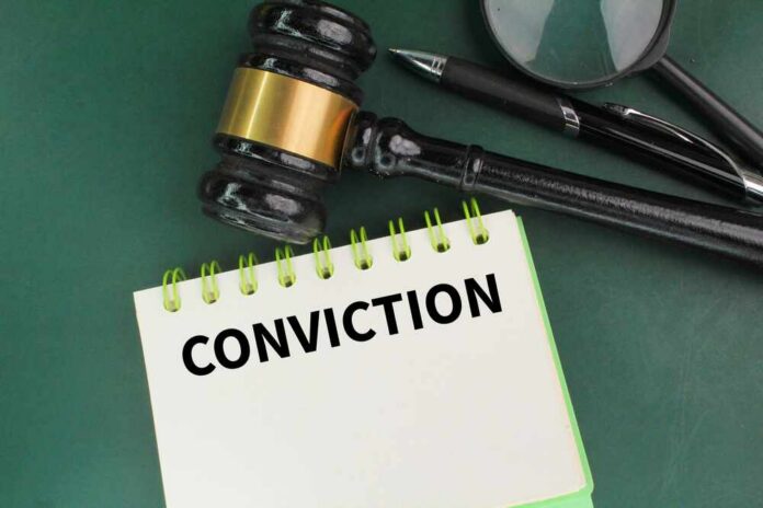 A gavel resting on a notepad with the word 'CONVICTION' written on it