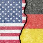 A cracked surface displaying the flags of the USA and Germany