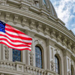American flag in front of ornate building facade.