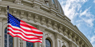 American flag in front of ornate building facade.