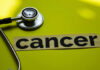 A stethoscope next to the word 'cancer' on a yellow background