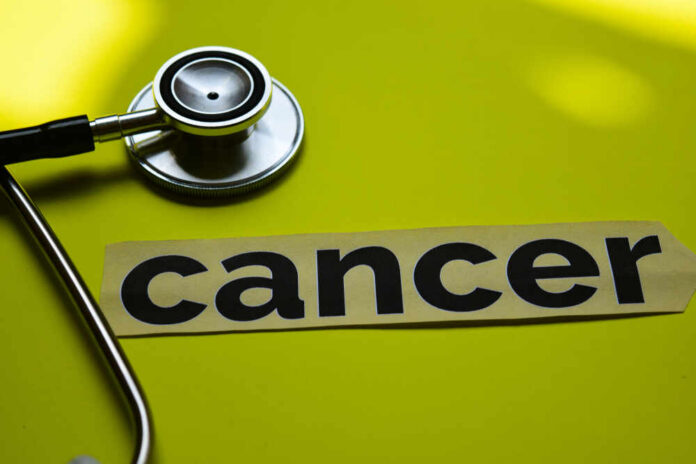 A stethoscope next to the word 'cancer' on a yellow background