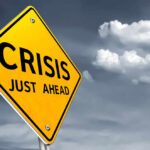 A yellow warning sign indicating a crisis ahead