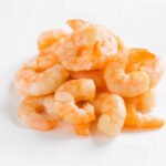 Endless Shrimp RETURNS After Earlier Chaos? A pile of cooked shrimp on a white background