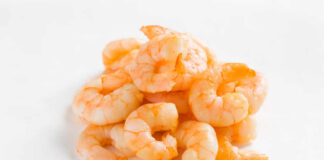 A pile of cooked shrimp on a white background
