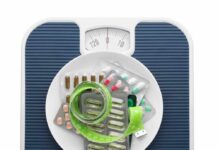 A scale topped with various medication packets and a measuring tape