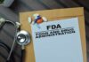 FDA document with pills and a stethoscope on a wooden surface