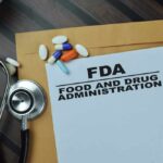 FDA document with pills and a stethoscope on a wooden surface