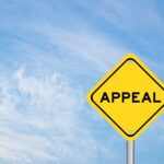 A yellow diamond-shaped sign with the word 'APPEAL' against a blue sky