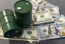 Two green oil barrels placed on a pile of hundred dollar bills