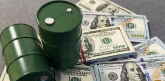 Two green oil barrels placed on a pile of hundred dollar bills