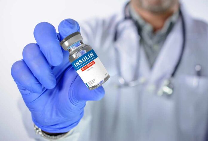 A healthcare professional holding an insulin vial in a gloved hand