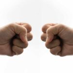Two fists facing each other in a gesture of camaraderie