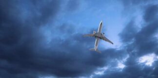 An airplane flying through a cloudy sky