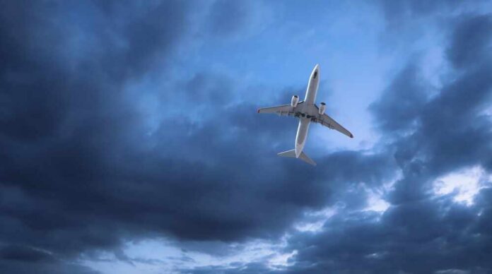 An airplane flying through a cloudy sky
