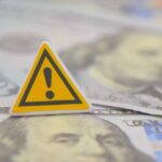 A warning sign placed on top of U.S. dollar bills