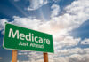 Green road sign indicating Medicare is just ahead