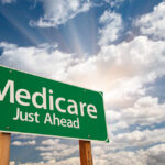 Green road sign indicating Medicare is just ahead