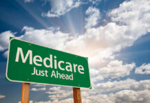 Green road sign indicating Medicare is just ahead