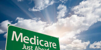 Green road sign indicating Medicare is just ahead