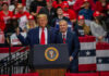 Trump’s BOMBSHELL: Snubs Party Leader In Key Race Two men speak at a political rally.