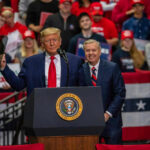 Two men speak at a political rally.