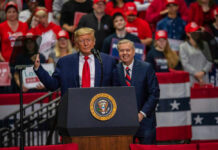 Trump’s BOMBSHELL: Snubs Party Leader In Key Race Two men speak at a political rally.