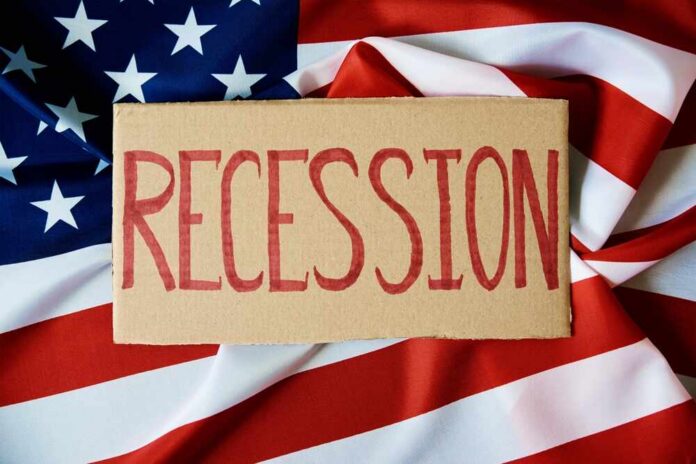 A cardboard sign reading 'RECESSION' placed on an American flag background