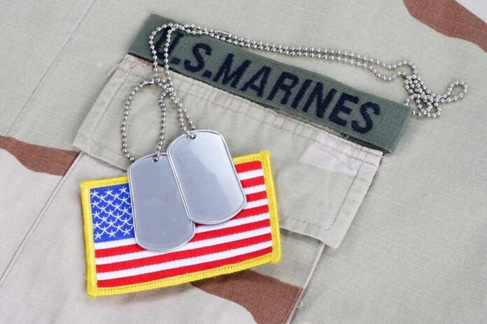 shutterstock_2271283307.jpg Close-up of military dog tags and an American flag patch on a US Marines uniform