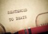 Close-up of a typewritten document stating 'SENTENCED TO DEATH'
