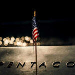 Pentagon’s ‘Self-Defense’ Strike Announced American flag above engraved Pentagon sign at night