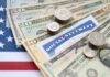 Various denominations of U.S. currency and a Social Security card on an American flag background