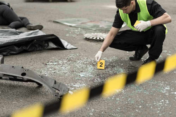 shutterstock_301329224.jpg Police investigating crime scene with evidence marker and body bag.