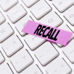 HUGE RECALL: 180K Vehicles Impacted A pink sticky note with the word 'RECALL' placed on a white keyboard
