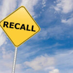 RECALL: Jars Turn Deadly – 3 Left Blind Yellow sign with RECALL text against blue sky.