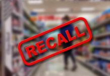 Gruesome Injury Triggers Amazon Recall Recall stamp on blurred store aisle background.