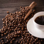 RECALL: Boiling Coffee Geysers? A cup of hot coffee next to spilled coffee beans and a wooden scoop