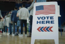 Trump Ally Surges — Enemies On Notice People in line next to Vote Here sign