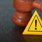 Name Grab Backfires — Judge Says Unlawful Judge's gavel beside yellow warning triangle sign