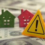 Investor Crackdown Sparks Housing War Colorful house models and a warning sign on dollar bills