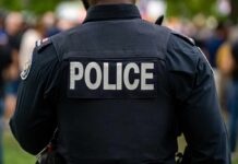Lib City Weekend Bloodbath Exposes Policy Failure Back view of a police officer wearing a uniform with 'POLICE' displayed
