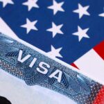 Close-up of a US visa on a background of the American flag