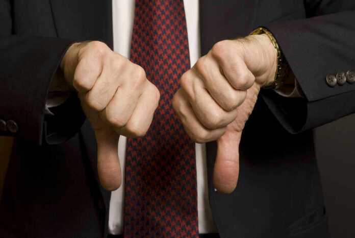 shutterstock_288126224 Two hands showing thumbs down in a suit.