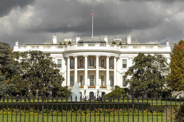 shutterstock_560339335 The White House with dark clouds overhead.